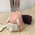 Cute pink bunny backpack with plush rabbit ears and star embroidery on bed setting - Pink Small