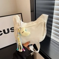 Details einer beigen Nylon-Halbmondtasche mit einem süßen gelben Mond-Plüschanhänger - Off-White Mit Anhänger