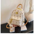 Detail view of mini backpack featuring bear print pattern and golden side rivet accents - Rice Yellow Bare Bag