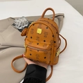 Brown mini backpack with bear monogram and gold rivets held by a stylish woman - Yellow (No Pendant)