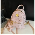 Pink printed mini backpack with bear charm and rivet details on a desk with laptop - Light Pink Bare Bag