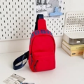 Red nylon crossbody chest bag for kids featuring blue UDIN lettering and adjustable strap - Large / Red