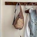 Detalle de bolso de pecho infantil estilo outdoor con patchwork marrón y cordón - Marrón