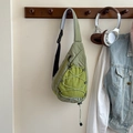 Detalle del bolso bandolera verde para niños con cordón elástico y etiqueta moda - Verde