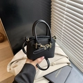 Close-up of black mini handbag featuring gold horsebit hardware and high-density fabric - Bare Bag / Black