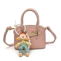 Pink woven mini handbag for kids featuring a cute cartoon charm and pearl strap - With Pendant / Light Pink
