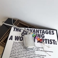 Dettaglio mini borsa argento con ciondolo di perline colorate e logo in rilievo - Argento