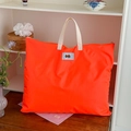 Detail van een feloranje nylon opbergtas met beige handvatten en kastanje-embleem - Oranje