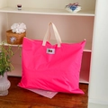 Detail van de neon roze nylon kindertas met crème canvas banden en kastanje label - Roze