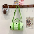 Light green contrast color kids cylinder crossbody bag hanging on a wooden rack - Fruit Green