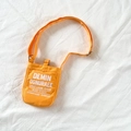 Mini orange canvas shoulder bag for kids featuring white typography and adjustable strap - Yellow