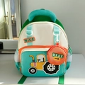 Detail eines minzgrünen Kinderrucksacks mit Traktormotiv und orangefarbener Münztasche - Grün