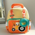 Detail eines Kinderrucksacks mit Traktor-Aufnäher und kleiner runder Geldbörse - Orange