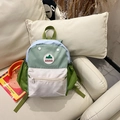 Kids backpack in green and white color block design placed on a beige sofa - Small / Green