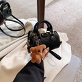 Detail of black lychee grain leather mini bag with gold hardware and bear charm - With Pendant / Black