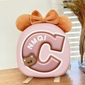 Close-up of pink hardshell kids backpack featuring a brown 3D bow and cartoon bear badge - Brown