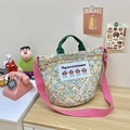 Quilted floral tote bag detail showing green handles and pink woven shoulder strap - Green