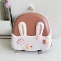 Detail des braun-weißen Cartoon-Hasen-Hartschalenrucksacks mit süßen 3D-Anhängern - Braun