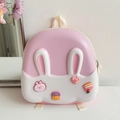 Detail eines rosa-weißen Kaninchen-Eierschalen-Rucksacks mit süßen 3D-Cartoon-Anhängern - Rosa
