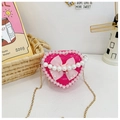 Close-up of heart-shaped handbag with glossy pink finish, lace trim and pearl accents - Rose Red Bow