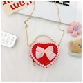 Detail of red heart-shaped handbag with lace trim, pearl handle, and mesh bow - Red Bow