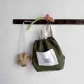 Dettaglio dello zaino verde scuro per bambini con tasca bianca e spallacci in tessuto - Verde