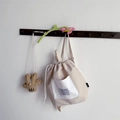 Dettaglio dello zaino con coulisse beige per bambini con tasche bianche e ganci a muro - Beige