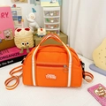 Detail einer lebhaften orangefarbenen Nylon-Kindertasche mit gestreiften Griffen und Stickerei - Groß / Orange