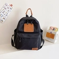 Black canvas preschool backpack for kids featuring a brown leather smiley face design - Black