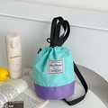 Detalle del bolso saco bicolor verde menta y púrpura con cordón y correa ancha de lona - Verde