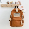 Mochila infantil minimalista de lona color marrón naranja con bolsillo y etiqueta - Caramelo