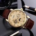 Close-up of rose gold automatic watch with leather strap on a desk with a camera - Gold Case Gold Dial Brown Strap