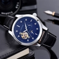 Business watch with blue sunray dial and leather strap on a notebook with camera gear - Silver Case Black Dial Black Strap