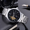 Macro view of automatic mechanical watch featuring a moon phase dial and steel band - Silver Case Black Dial