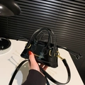 Mini zwarte laks lederen handtas met glanzende afwerking en gouden hardware details - Zwart