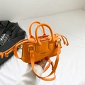 Mini orange crossbody bag with round handles and secure drawstring liner pouch - Orange