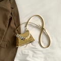Golden mirror finish handbag with white pearl strap and silver heart chain detail - Gold