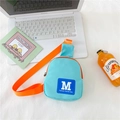 Sac de poitrine tendance bleu et orange pour enfants posé sur un ordinateur blanc - Vert