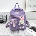 Cute purple nylon kids backpack featuring a plush white bunny doll and plaid pocket detail - Purple