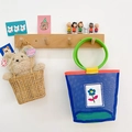 Blue mesh kids tote bag with green handles, flower patch, and cute bear in a woven basket - Blue