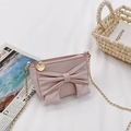 Pink girl's mini crossbody bag featuring a large bow and golden heart chain - Pink