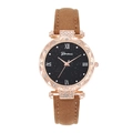 Détail du cadran noir étoilé avec strass et boîtier en or rose sur bracelet en cuir - Marron
