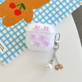 Macro view of translucent glitter AirPods case with purple bows and pearl charm - Purple