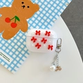 Dettaglio custodia AirPods Pro traslucida con fiocco rosso, perle e portachiavi dorato - Rosso / Gen 1/2