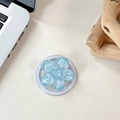 Draufsicht auf einen hellblauen Blumen-Handyhalter aus Harz mit Glitzer auf einem Tisch - Magnetisch Macaron Pailletten Sakura Nr. 3