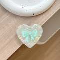 Detail of heart-shaped iridescent phone grip with green bow and sparkling rhinestones - Transparent Stand - Shell Heart - Jelly Bow / Green