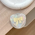 Dettaglio macro del supporto telefono a cuore con finitura laser iridescente e fiocco - (Strass Bianco) Magnetico - Cuore di Conchiglia - Fiocco di Gelatina / Giallo