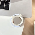 Detail der runden Katzenohr-Handyhalterung mit integriertem Spiegel auf weißem Tisch - Magnetischer Katzen-Spiegel mit Muscheltextur / Cremeweiß