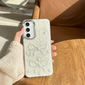 Hand holding cream Samsung S24 Ultra case with glitter swirls, pearls and blue bows - Electroplated Frame - White Glitter Drip Glue - 2 Laser Butterflies / Samsung A16