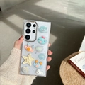 Detalle de adornos 3D de cangrejo y ballena en una funda transparente con purpurina - Marco Galvanizado-Estrellado-Cangrejo Concha(Samsung A16)